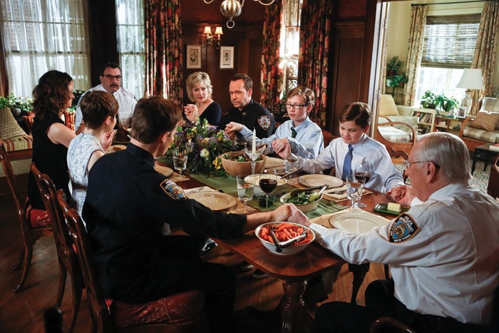 Frank Reagan (Tom Selleck) and his family pray before a meal on the CBS series Blue Bloods.